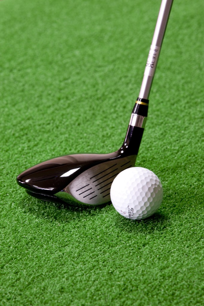 Club de golf et balle sur le green